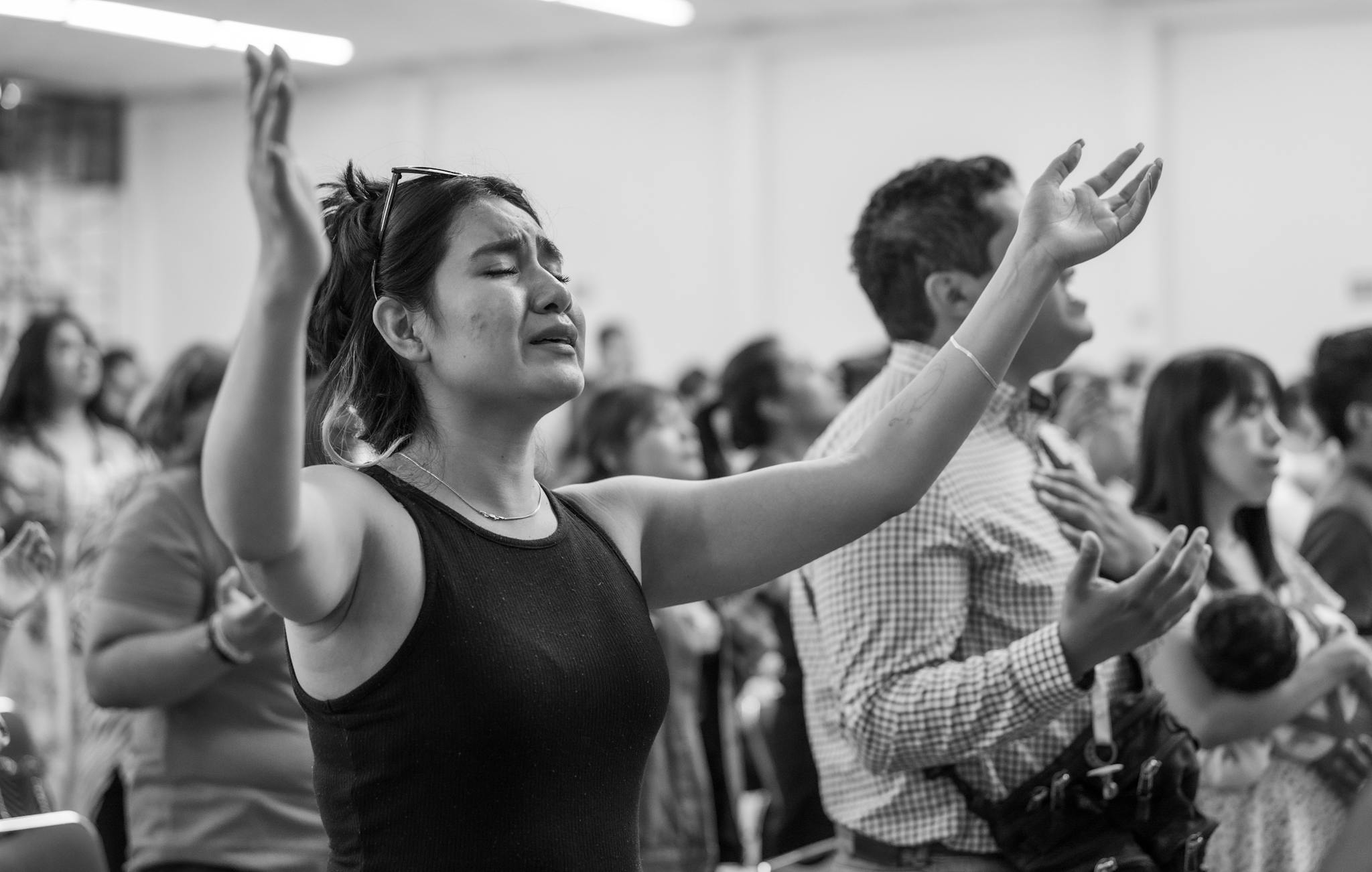 A diverse group of people worshipping in a religious setting in Mexico City.